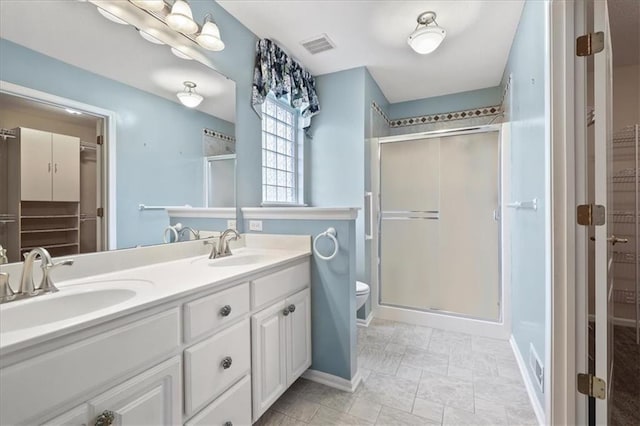 bathroom featuring visible vents, a sink, and a shower stall
