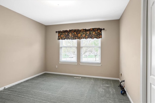 empty room featuring baseboards and carpet