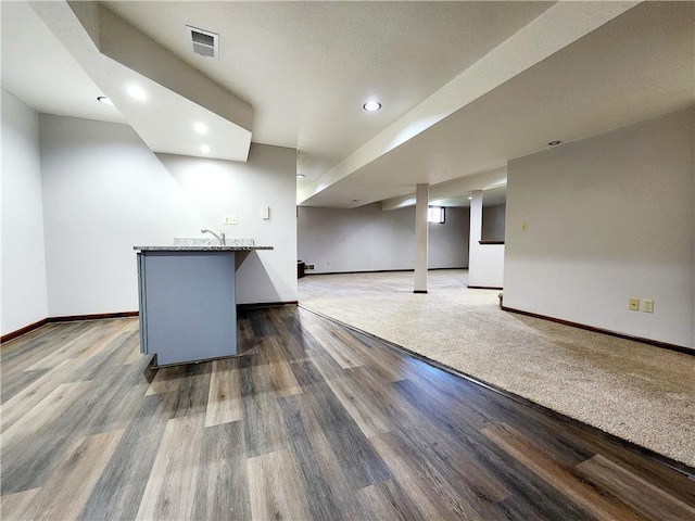 finished basement featuring wood finished floors, baseboards, visible vents, and recessed lighting
