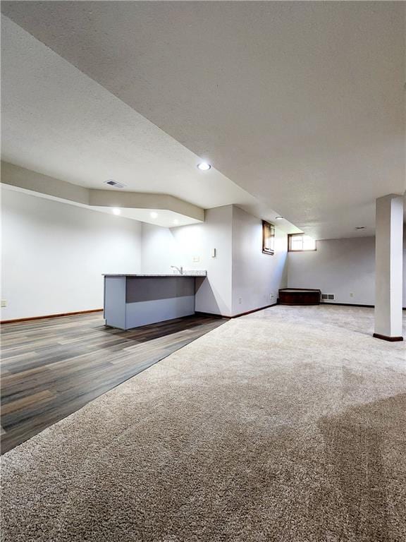 below grade area featuring recessed lighting, visible vents, baseboards, and carpet floors