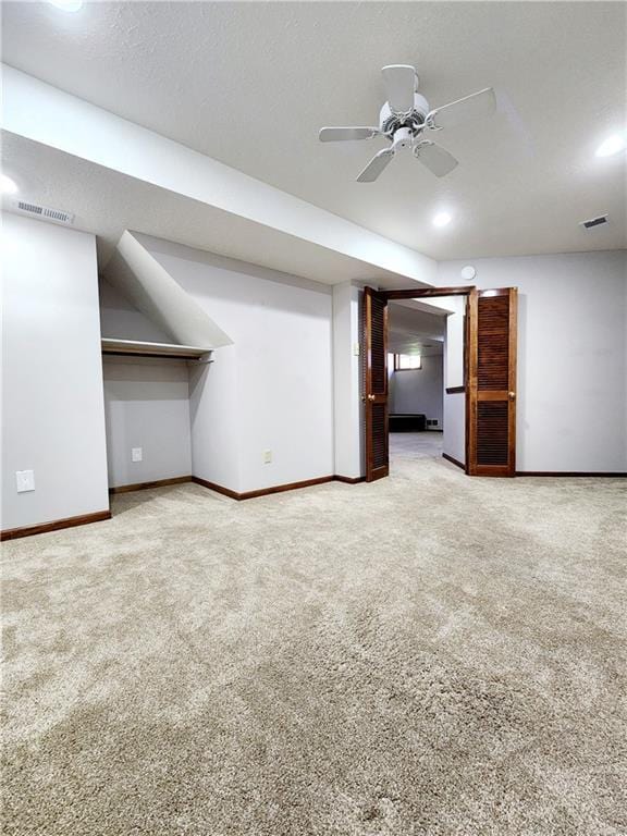 interior space featuring ceiling fan, visible vents, baseboards, and carpet