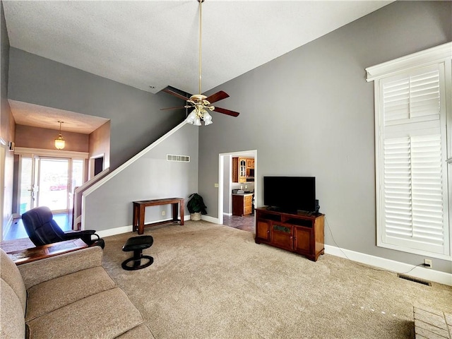 living room featuring carpet, a ceiling fan, visible vents, lofted ceiling, and baseboards