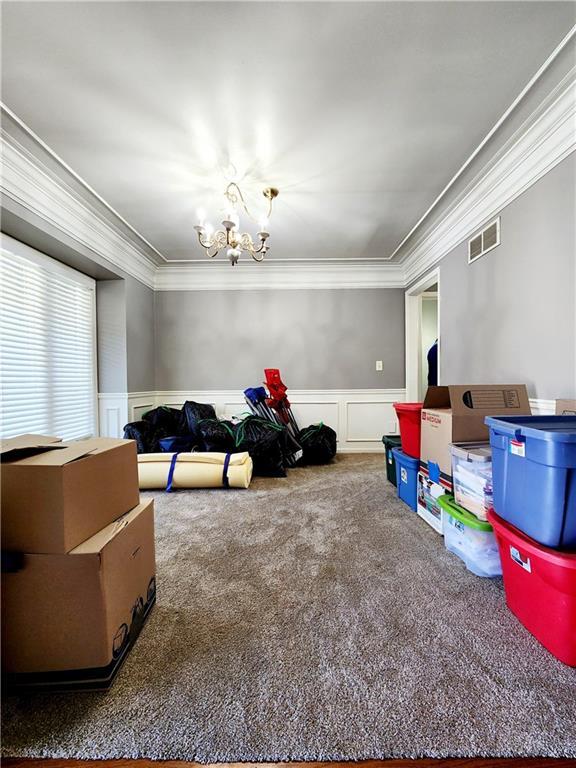 rec room featuring ornamental molding, a chandelier, visible vents, wainscoting, and carpet