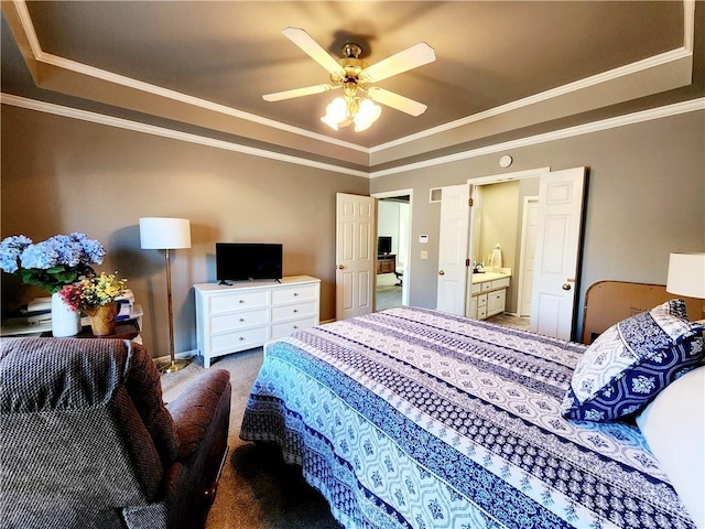 carpeted bedroom with crown molding, a tray ceiling, and a ceiling fan