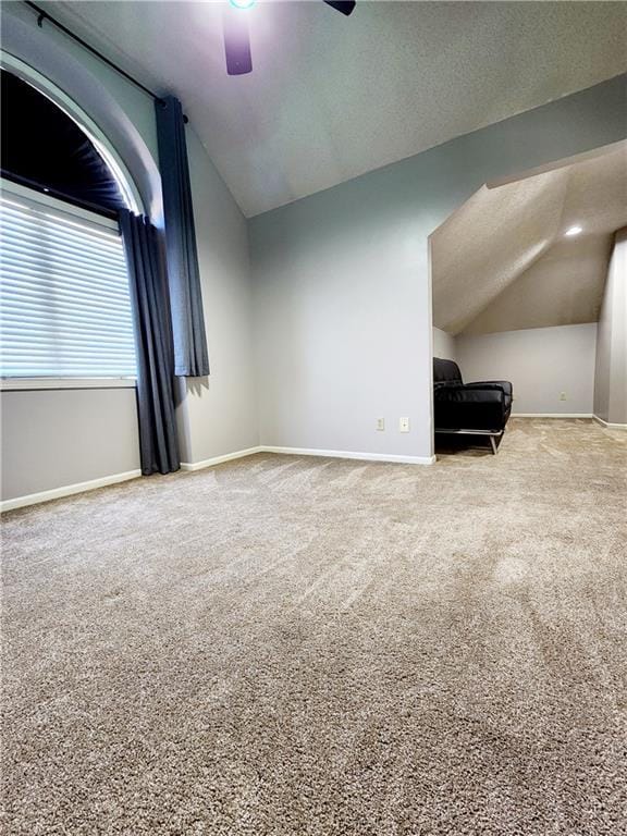 additional living space with ceiling fan, baseboards, carpet flooring, and vaulted ceiling