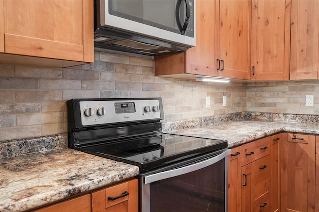 kitchen with backsplash, stainless steel electric range oven, and light stone counters