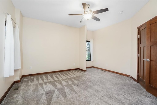 unfurnished bedroom featuring a ceiling fan, baseboards, and light colored carpet