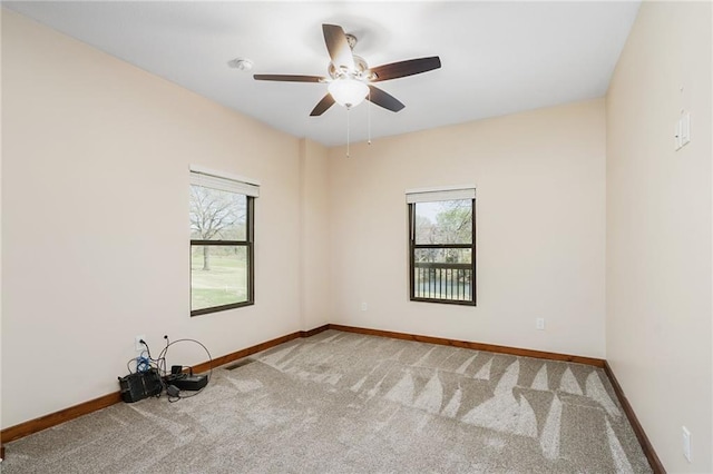carpeted empty room featuring baseboards, ceiling fan, and a healthy amount of sunlight