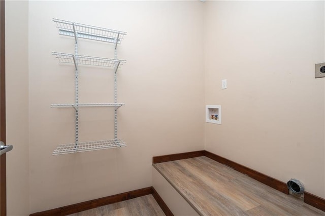 clothes washing area with hookup for a washing machine, wood finished floors, hookup for an electric dryer, baseboards, and laundry area
