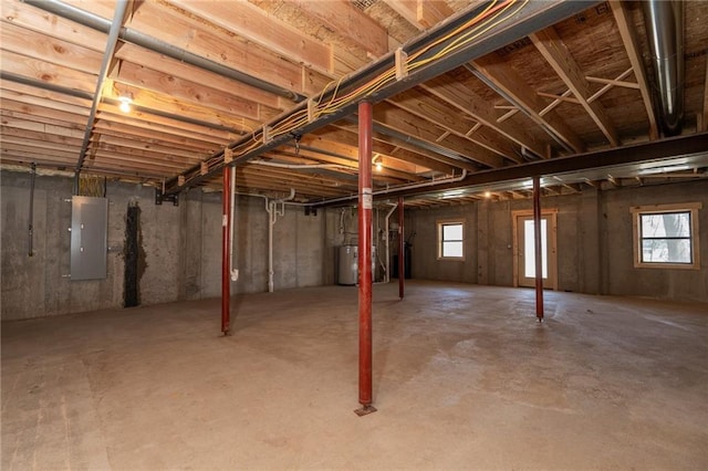below grade area featuring water heater, electric panel, and a healthy amount of sunlight