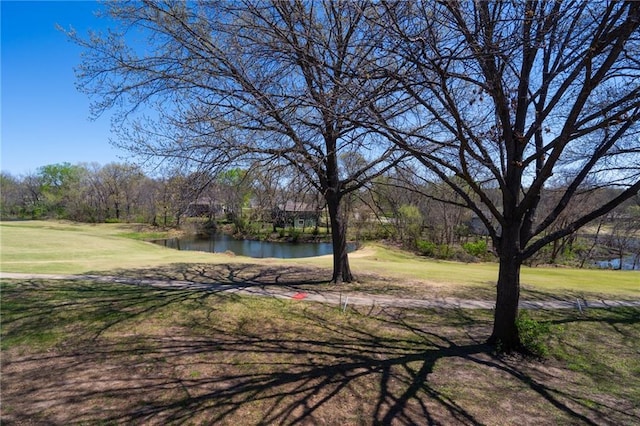 view of yard with golf course view and a water view