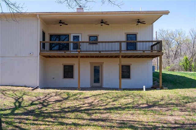 rear view of house featuring a lawn and ceiling fan