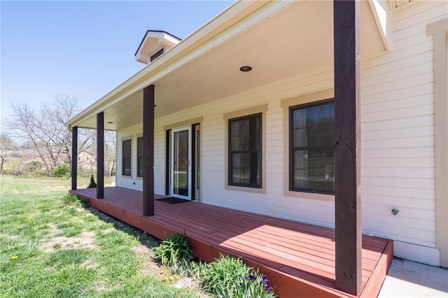 wooden deck with a porch and a lawn