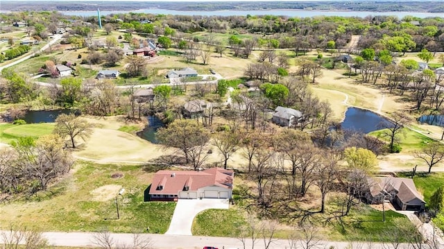 aerial view with golf course view, a residential view, and a water view
