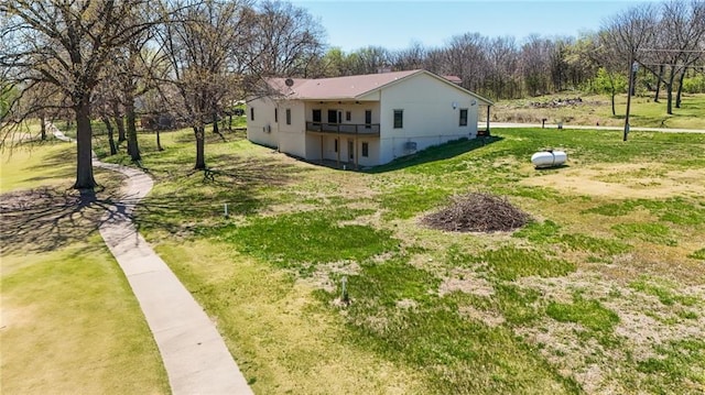 view of property exterior with a yard and a balcony
