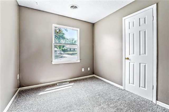 unfurnished room featuring carpet flooring, baseboards, and a textured ceiling