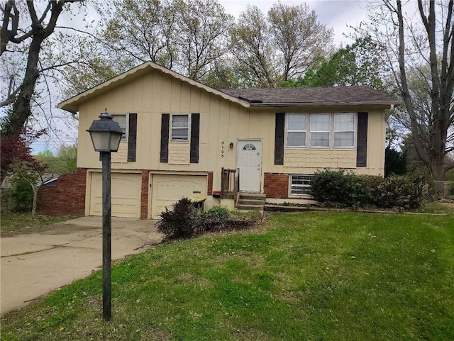bi-level home with brick siding, driveway, a front yard, and a garage