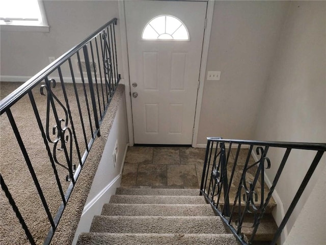 stairway with stone finish floor and baseboards