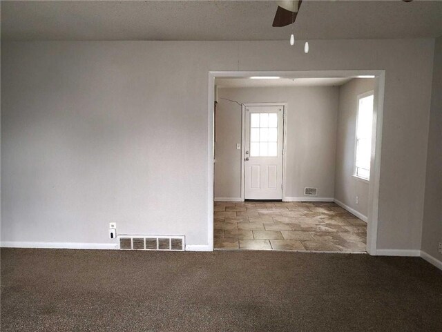 unfurnished room with ceiling fan, baseboards, visible vents, and carpet