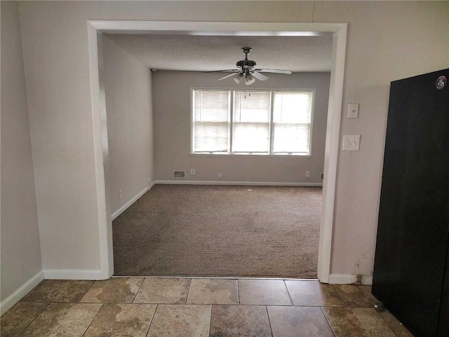 empty room featuring baseboards, carpet flooring, and ceiling fan