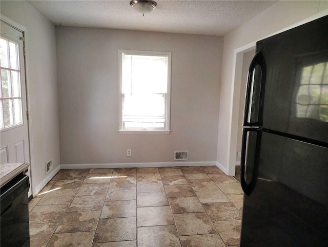 unfurnished dining area with baseboards and a textured ceiling