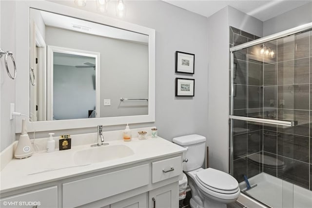 bathroom with vanity, a stall shower, visible vents, and toilet