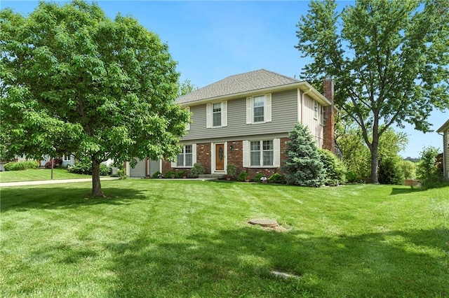 colonial home with a chimney, a front lawn, and brick siding