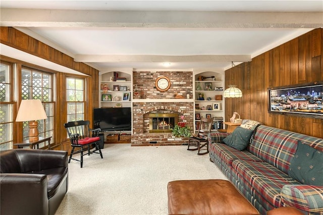 carpeted living area with wooden walls, beamed ceiling, and a brick fireplace
