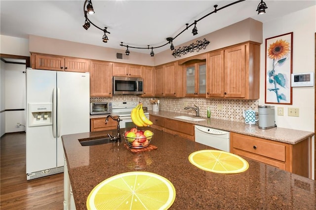 kitchen with white appliances, a sink, backsplash, and glass insert cabinets