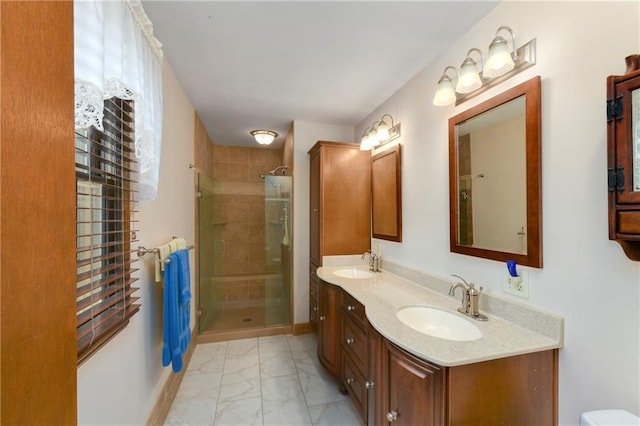 full bath featuring marble look tile flooring, a shower stall, and double vanity
