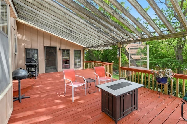 wooden terrace featuring a fire pit and a pergola