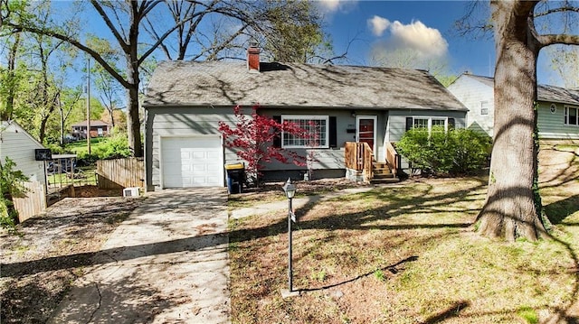 view of front of house with concrete driveway, a chimney, and a garage