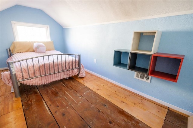 bedroom featuring vaulted ceiling, baseboards, and wood-type flooring