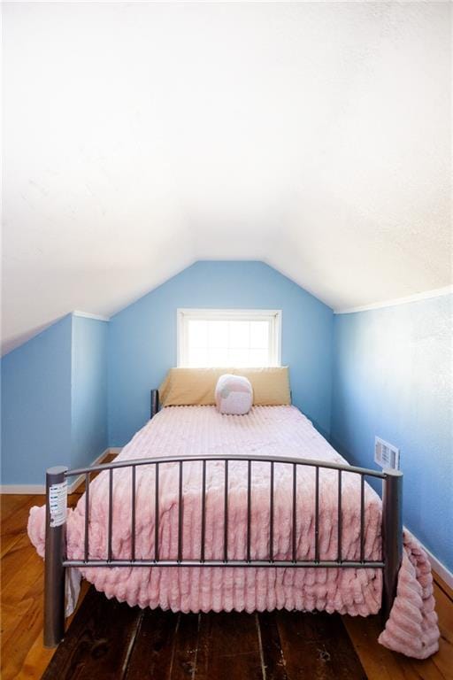 bedroom featuring vaulted ceiling, visible vents, and baseboards