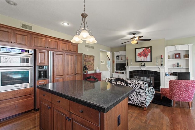 kitchen with a ceiling fan, double oven, dark wood-style floors, and visible vents