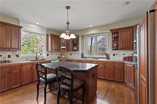 kitchen with a sink, open shelves, and wood finished floors