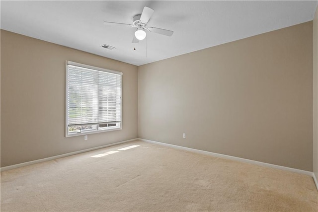 spare room with carpet floors, baseboards, and visible vents