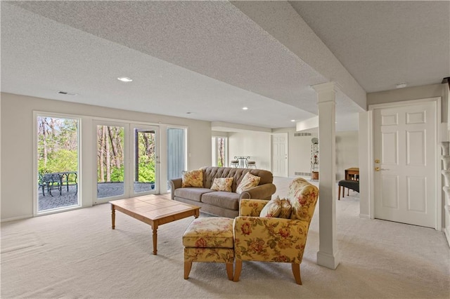 living area featuring visible vents, a textured ceiling, and light carpet