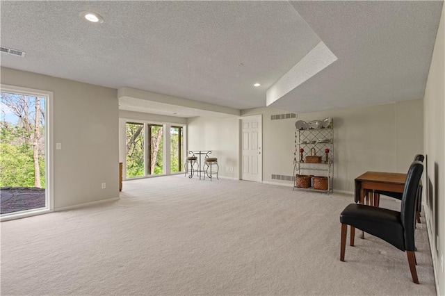 sitting room with visible vents, a textured ceiling, carpet floors, and baseboards