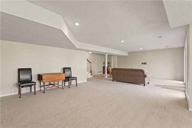 sitting room with light colored carpet, a textured ceiling, baseboards, and stairway