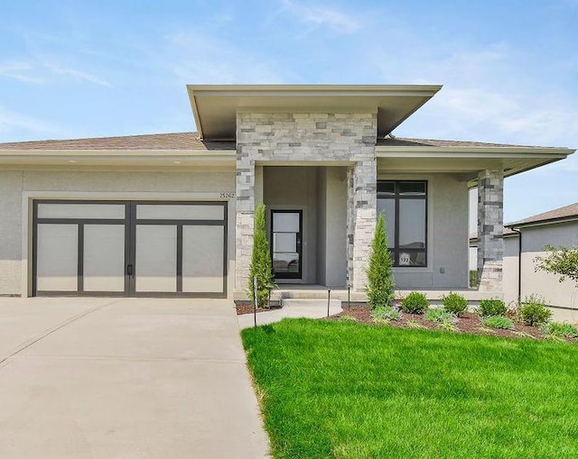 16159 S Kaw St, Olathe, KS 66062 - prairie-style house with driveway, a garage, stone siding, a front yard, and stucco siding