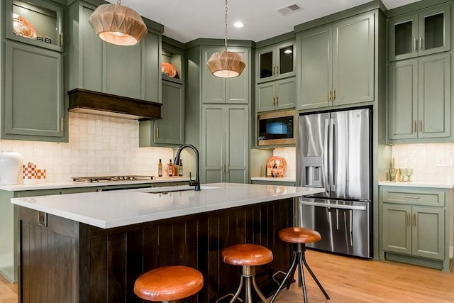 16159 S Kaw St, Olathe, KS 66062 - kitchen featuring green cabinets, stainless steel appliances, a sink, light countertops, and decorative backsplash