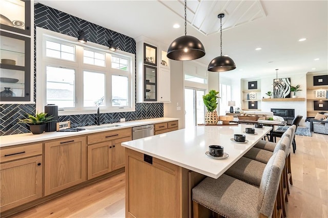 15436 W 161st Ter, Olathe, KS 66062 - kitchen with a sink, light wood-type flooring, dishwasher, a breakfast bar area, and light countertops