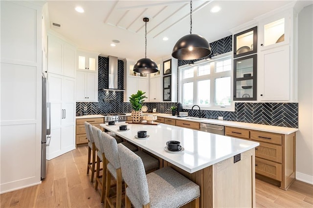 15436 W 161st Ter, Olathe, KS 66062 - kitchen with wall chimney range hood, appliances with stainless steel finishes, a sink, a breakfast bar area, and recessed lighting