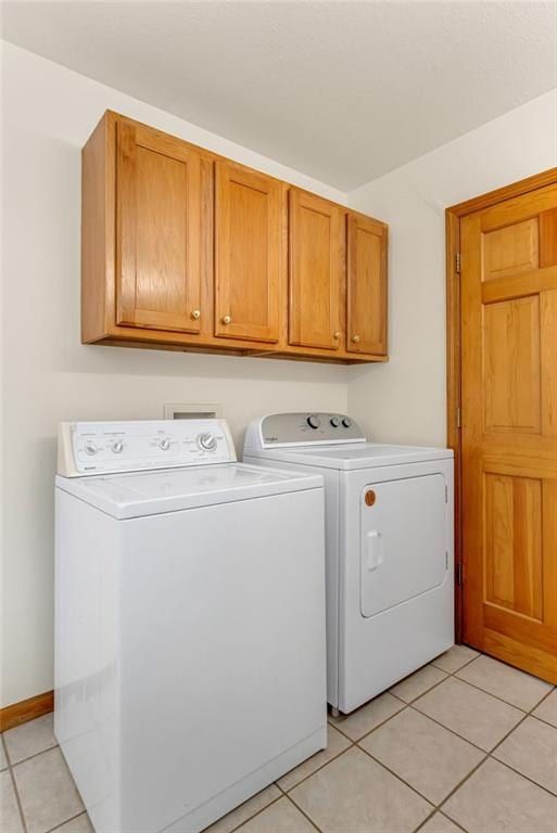 4955 Saratoga Dr, Mclouth, KS 66054 - laundry room with washer and dryer, light tile patterned floors, and cabinet space