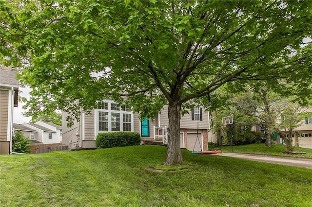 view of front of house featuring an attached garage, driveway, and a front yard
