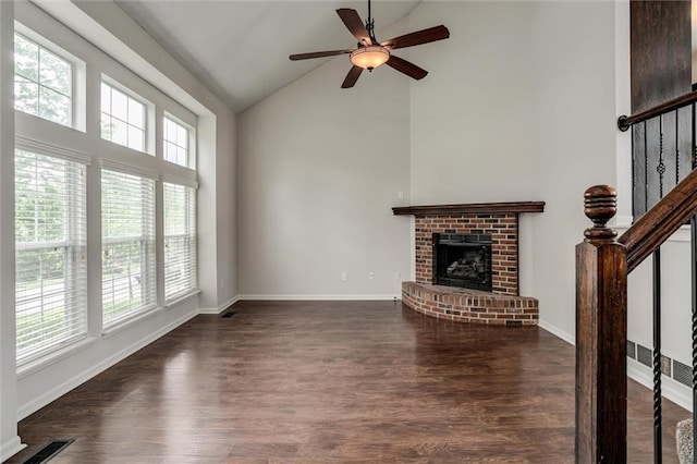 unfurnished living room with visible vents, a brick fireplace, wood finished floors, ceiling fan, and high vaulted ceiling