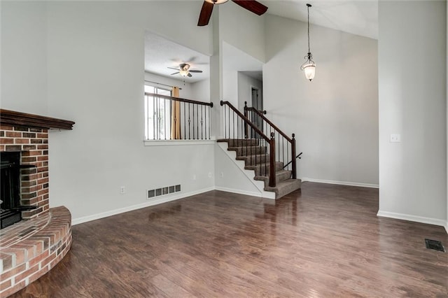 unfurnished living room with a ceiling fan, visible vents, and wood finished floors