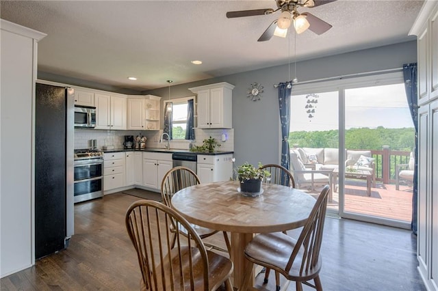 50 N 80th Pl, Kansas City, KS 66111 - kitchen featuring stainless steel appliances, dark countertops, tasteful backsplash, a ceiling fan, and dark wood-style flooring