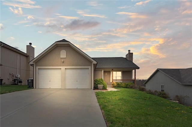 single story home featuring a chimney, a yard, stucco siding, an attached garage, and driveway